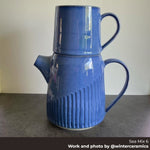 Blue ceramic pitcher with ribbed design on a gray surface. Made with Seattle Pottery Supply Sea Mix 6 clay