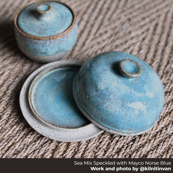 Two lidded bowls made from Seattle Pottery Supply sea mix speckled clay and norse blue glaze on a woven surface